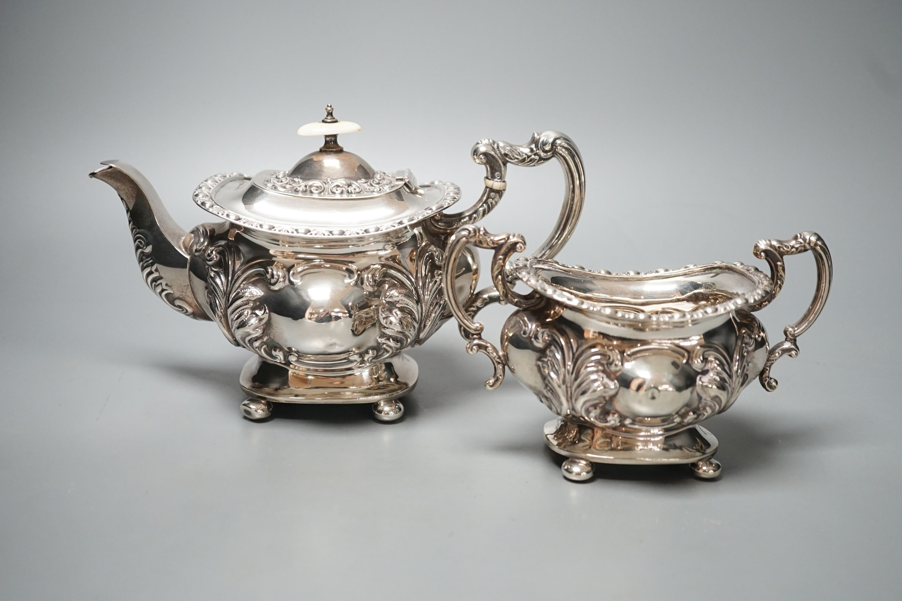 An Edwardian embossed silver teapot and matching sugar bowl, William Aitken, Chester, 1903, gross 21.5oz.